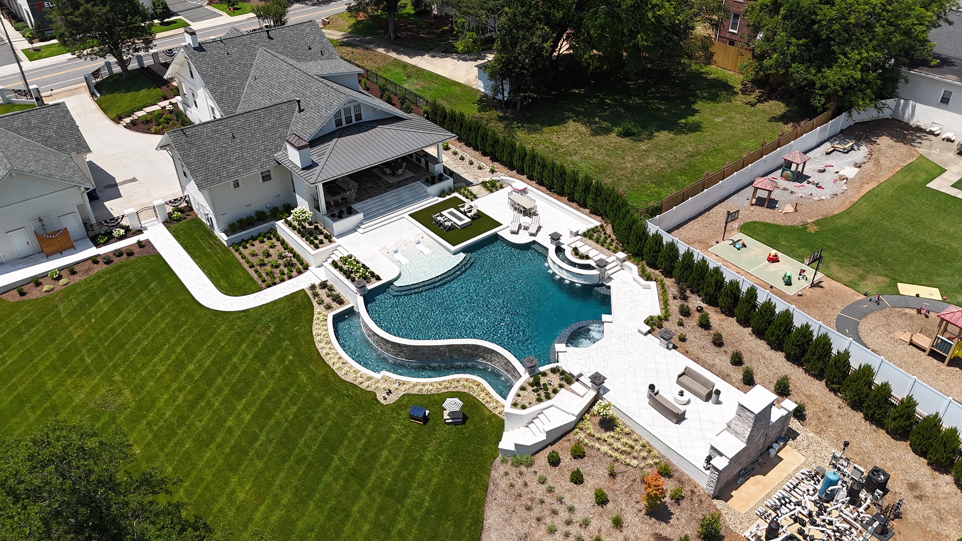 Kidney-shaped pool with stone waterfall and natural rock landscaping